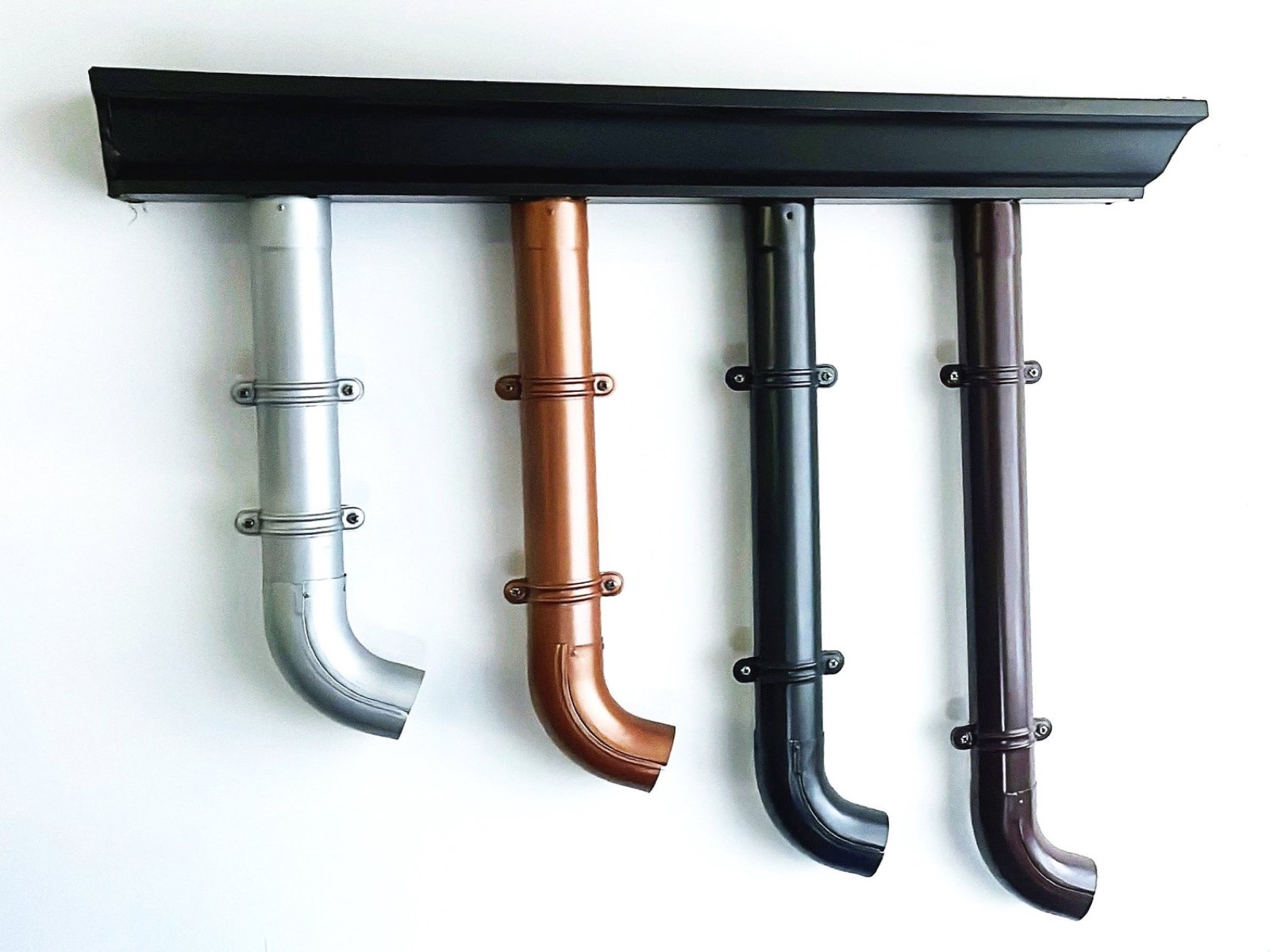 Muestrario ALCUZINC: canalón negro con cuatro bajantes en aluminio natural, cobre, gris antracita y marrón